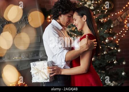 Girl holds white gift box. New Year's evening dancing. Lovely gorgeous couple spending time together Stock Photo