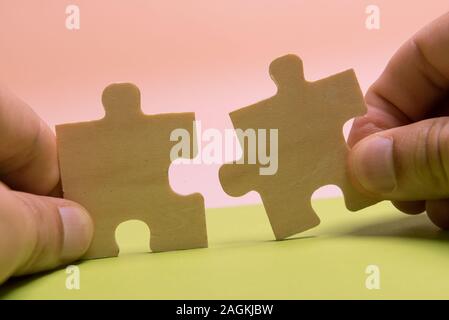 Man hand assembling puzzles on lime background. Stock Photo