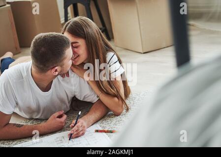Filing document. Cheerful young couple in their new apartment. Conception of moving Stock Photo