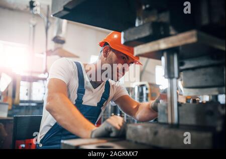 Concentrated look. Man in uniform works on the production. Industrial modern technology Stock Photo