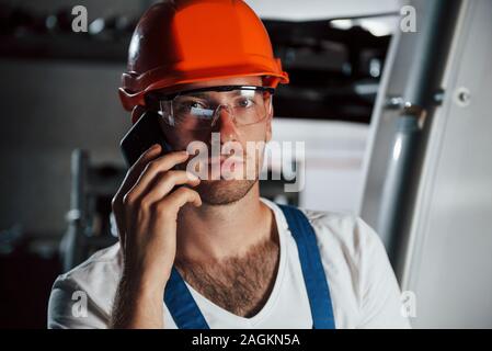 Having conversation. Portrait of engineer in metallurgical factory in protective helmet and eyewear Stock Photo