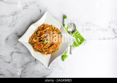 Hailam Mee Hoon or known as rice vermicelli with gravy, is an Asia dish braised with dark and light soy sauce. Flat lay on table. Stock Photo