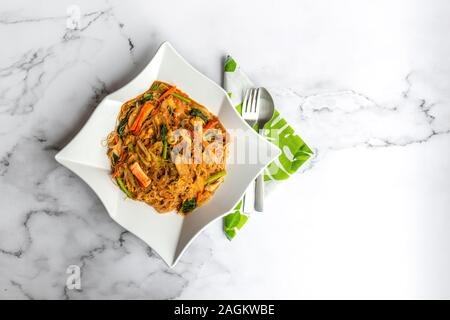 Hailam Mee Hoon or known as rice vermicelli with gravy, is an Asia dish braised with dark and light soy sauce. Flat lay on table. Stock Photo