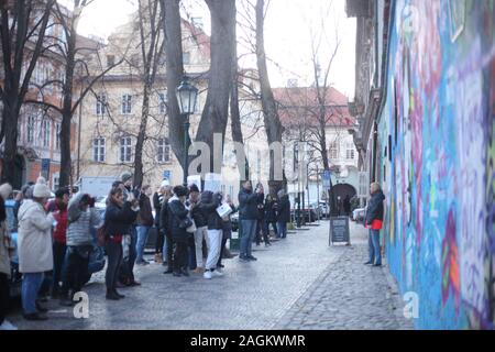 View of crowds of tourists gathering at the John Lennon Memorial Wall in Prague City, Czech Republic. December 2019. Stock Photo