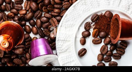 Open Espresso coffee capsules or pods and coffee beans on grey background, top view. Making coffee at home concept. Stock Photo