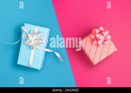 His and Hers, blue and pink wrapped presents on colored background  - Holidays and celebrations concept image. Stock Photo