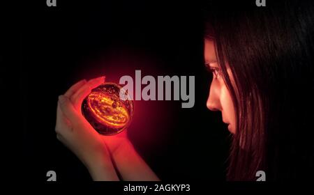 Divination and fortune-telling, magical, spiritistic and witchcraft sessions for good luck and luck in life. A fortune teller looks into a magic ball. Stock Photo