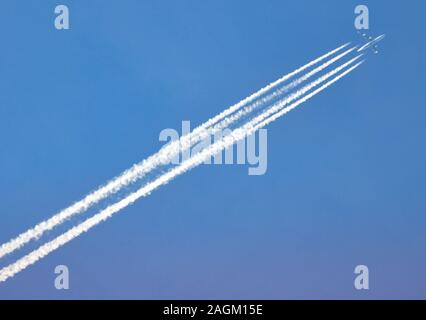 17 December 2019, Brandenburg, Potsdam/Ot Fahrland: An airplane draws contrails back and forth. The artificial clouds behind high-flying aircraft are created in cold air by moisture and combustion particles escaping and condensing from the engines. Photo: Soeren Stache/dpa-Zentralbild/dpa Stock Photo