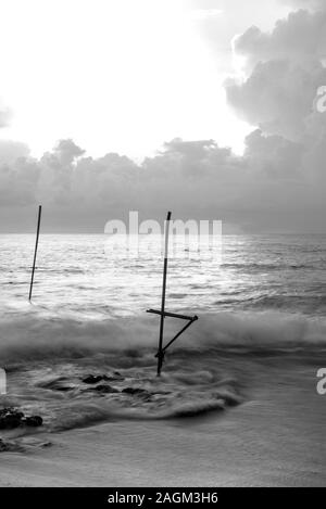 Koggala, Sri Lanka : 2019 Nov 18 :Silhouettes of the traditional Sri Lankan stilt fishermen on a stormy in Koggala, Sri Lanka. Stilt fishing is a meth Stock Photo