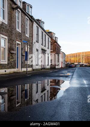 Bute, Scotland, UK - January 12, 2012: Traditional terraced stone cottages are reflected in a puddle in Port Bannatyne village on Scotland's Isle of B Stock Photo