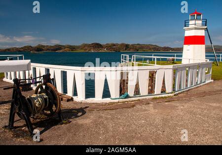 An old winch and beacon stand on the shore of Loch Crinan beside the Crinan Canal basin in the West Highlands of Scotland. Stock Photo