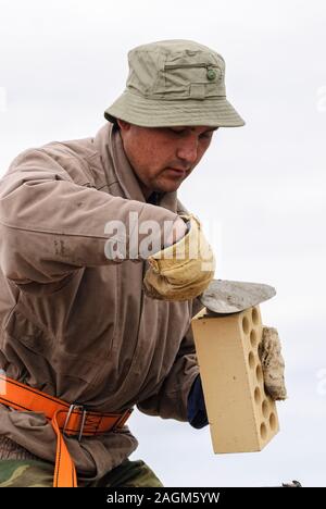 Bricklayer works on house construction Stock Photo
