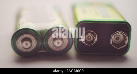 Two different types of batteries on the table close-up. Stock Photo