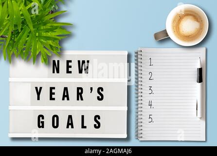 new years goals or resolutions concept with top view of lightbox and notepad on desk Stock Photo