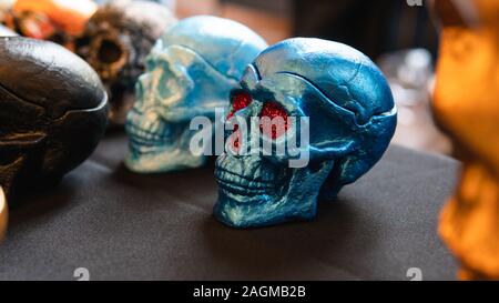 A collection of multi-colored ceramics skulls, close-up. Hand painted skulls for Halloween and Mexican Day of the dead decoration. Stock Photo