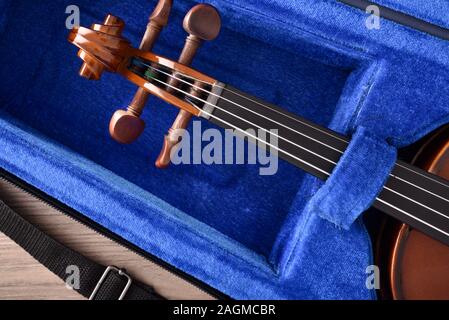 Student violin in case on wooden table detail. Top view. Horizontal composition. Stock Photo
