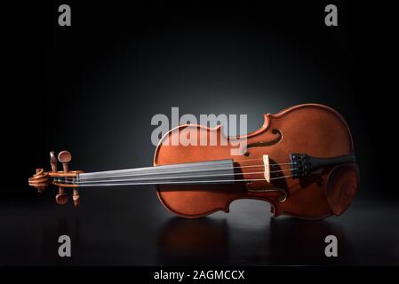 Violin reflected on wooden table and black gradient background. Horizontal composition. Stock Photo