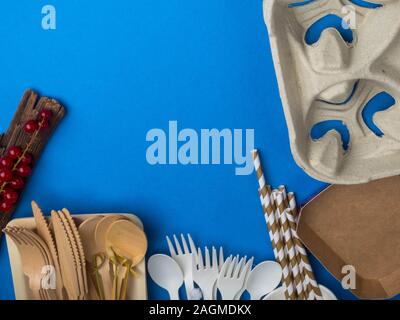 Ecological biodegradable and plastic disposable tableware for food, red berries on a blue background Stock Photo