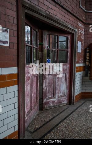 Partially open doors with faded red paint. Stock Photo