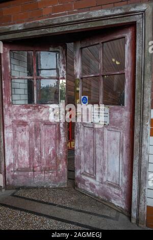 Partially open doors with faded red paint. Stock Photo