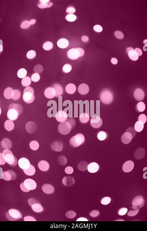 Dark pink background with bright warm bokeh lights. Holiday, Christmas and New Year background. Ideal to layer with any design. Horizontal Stock Photo