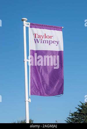 Westergate, West Sussex, UK, October 06, 2019. Taylor Wimpey Flag fluttering in the breeze at the entrance to the new The Hedgerows development. Stock Photo