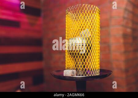 A whole hookah is on the table in the restaurant, smoke, golden mine, dark wood, club, hookah, rest in the lounge bar Stock Photo