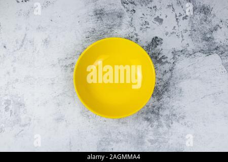 empty yellow bowl on concrete table background. Stock Photo