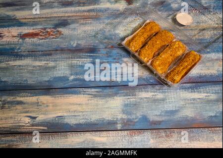 Four cakes in a plastic container on a wooden background Stock Photo