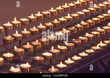 Many candles fire lit in the church Stock Photo