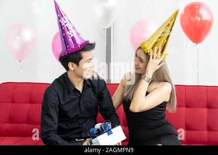 Portrait of couple holding gift box present celebraing New Year Party festival holiday in living room Stock Photo