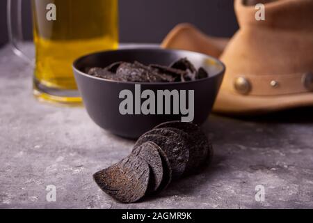 Mexican corn chips nachos, glass of beer and cowboy hat. Black chips nachos for brutal men Stock Photo