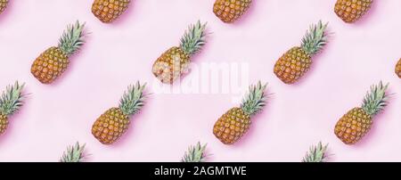 Creative food pattern with pineapples on pink backgound. Stock Photo