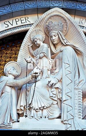 Lourdes in South-west France.Statue of the Virgin Mary giving the rosary to St.Dominic.Statue by Maniglier '1890' on Basilica of the Rosary Stock Photo