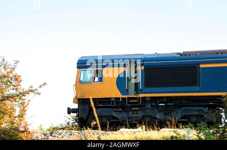 A freight train travels across the British countryside taking goods from A to B. Stock Photo