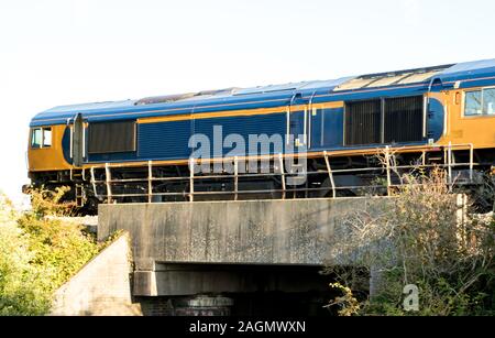 A freight train travels across the British countryside taking goods from A to B. Stock Photo