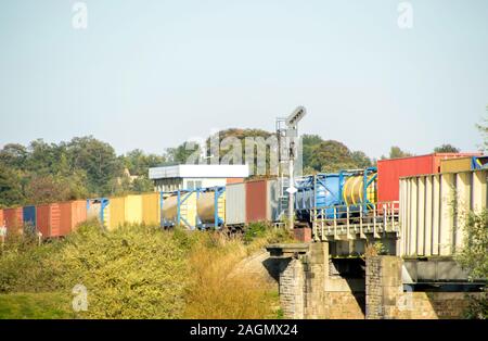 A freight train travels across the British countryside taking goods from A to B. Stock Photo