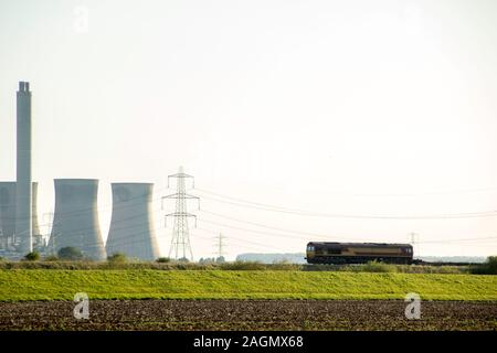 A freight train travels across the British countryside taking goods from A to B. Stock Photo