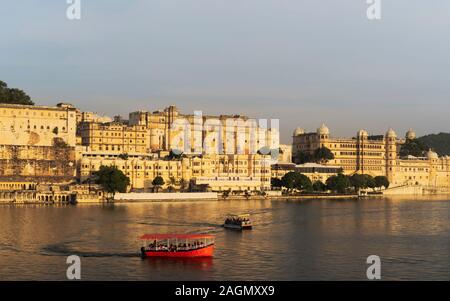 City Palace as viewed across Lake Pichola with tourist boats at dusk on a fine summer day in Udaipur, Rajasthan, India. Stock Photo