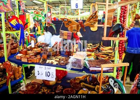 Puerto Limon, Costa Rica - December 8, 2019: Ethnic souvenirs, baseball caps, bags with various pattern hanging in street market Stock Photo