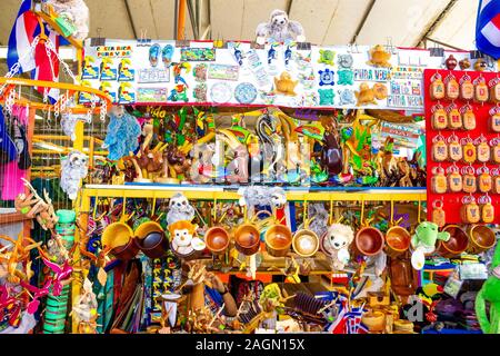 Puerto Limon, Costa Rica - December 8, 2019: Ethnic souvenirs, baseball caps, bags with various pattern hanging in street market Stock Photo
