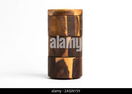 A towering three-level set of bamboo wood condiments vessel with lid cover set on a plain white background. Stock Photo