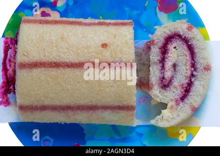 M&S Raspberry Trifle Roulade sponge filled with a creamy custard mousse and raspberry compote on plate with slice cut Stock Photo