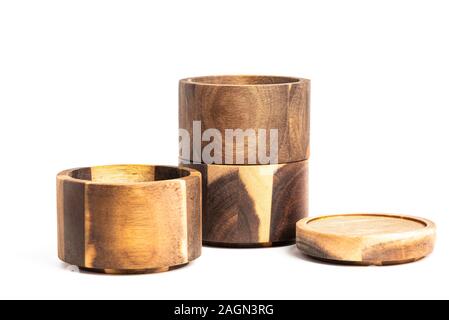 Three separate levels of stacking bamboo wood condiments vessel with lid cover on a plain white background. Stock Photo