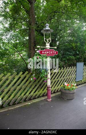 A traditional British gaslamp adorned with a hanging basket on the platform at Haworth Railway station, West Yorkshire, U.K. Stock Photo