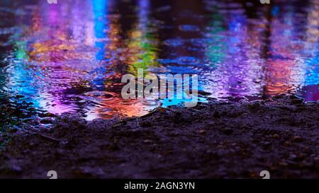 Colorful paint as abstract reflection in puddle at the fair Stock Photo