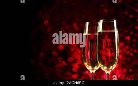 Two champagne glasses on sparkling red bokeh background. Celebration toast flutes. Valentine's day dinner invitation. Christmas and new year holiday p Stock Photo