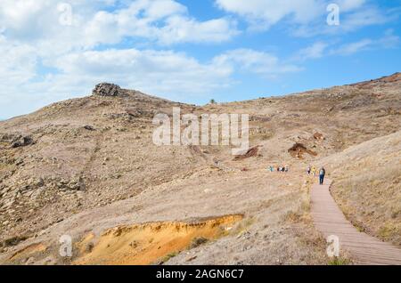 Ponta de Sao Lourenco, Madeira, Portugal - Sep 12, 2019: People on a hiking trail on the cliffs in the easternmost point of Madeira Island. The path through the volcanic landscape. Active vacation. Stock Photo