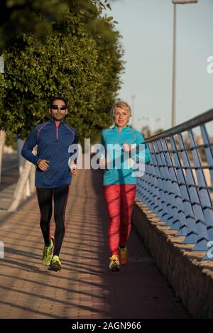 Two happy athletes jogging on the city street, Alicante, Spain Stock Photo