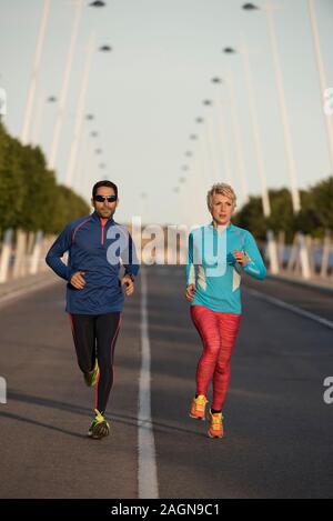Two happy athletes jogging on the city street, Alicante, Spain Stock Photo